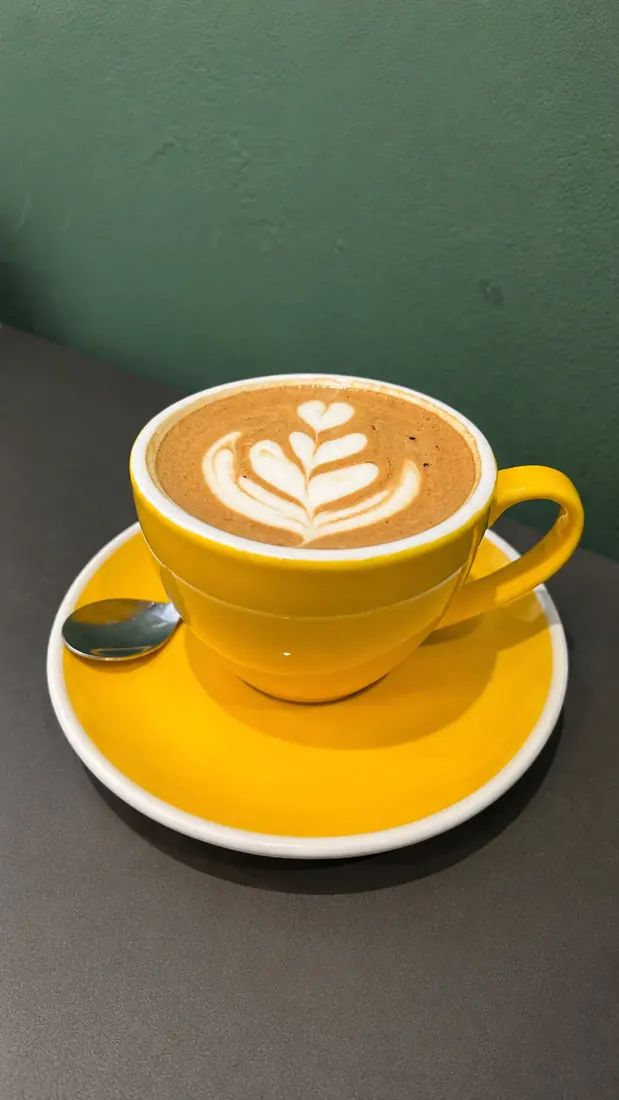 Latte art en taza amarilla
